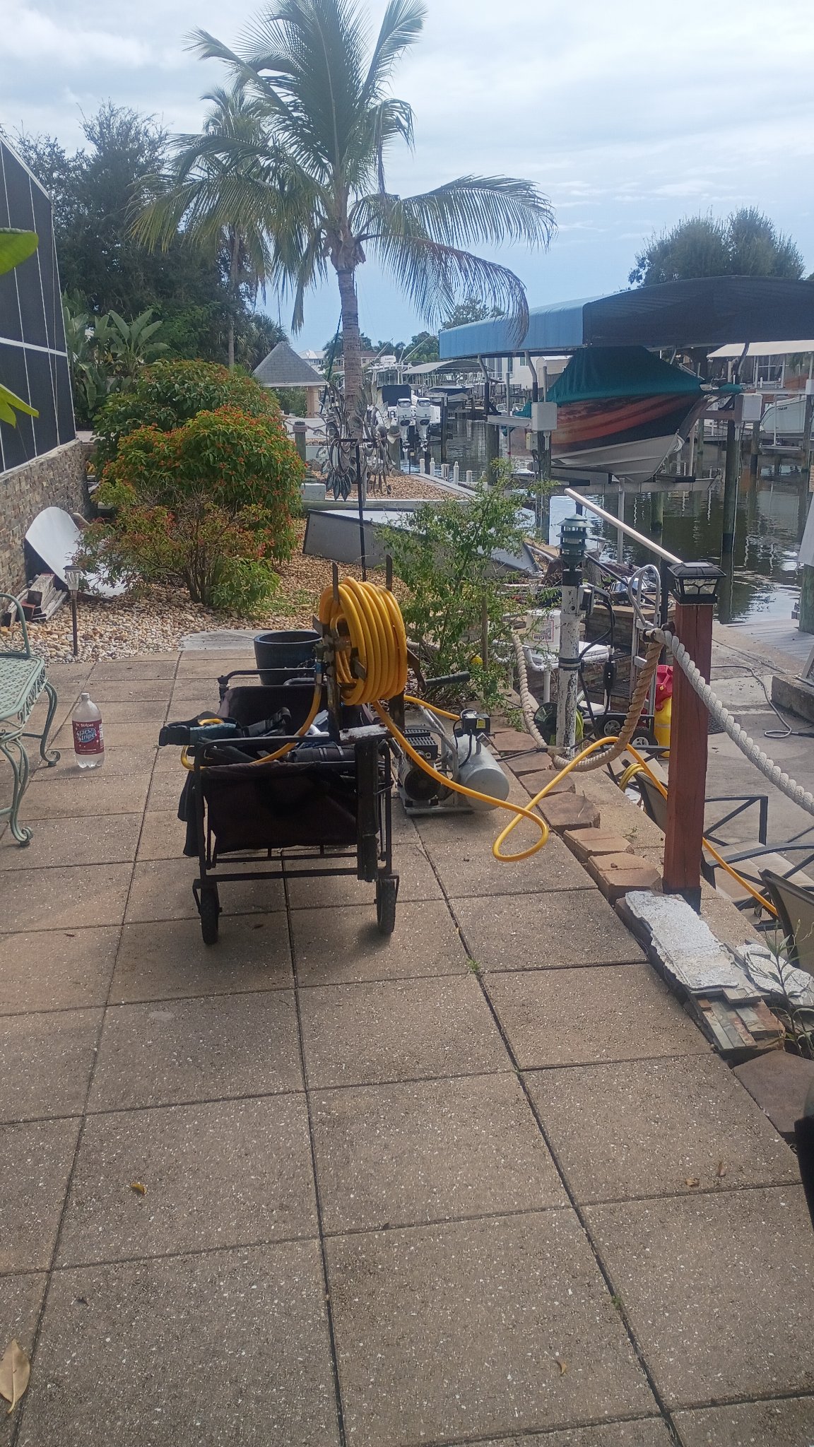 Crew member crouched beside dive support equipment at an outdoor site