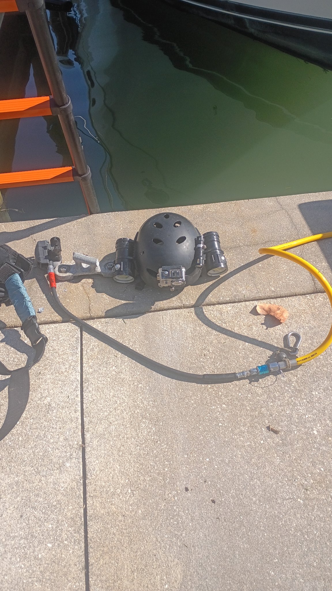 Dive line and equipment arranged on pavement near a work area